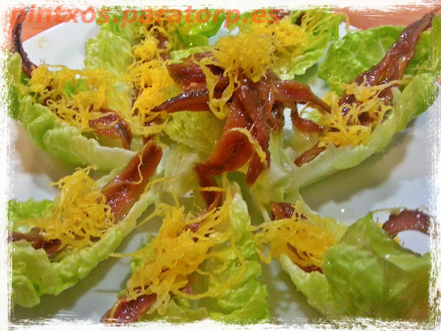 Anchoas sobre hojas de lechuga y huevo hilado