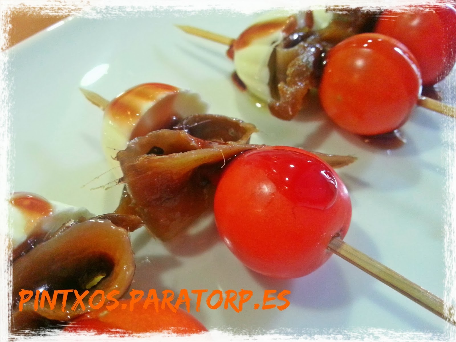 Brochetas de anchoa, cherry y queso de burgos con vinagre de frambuesa